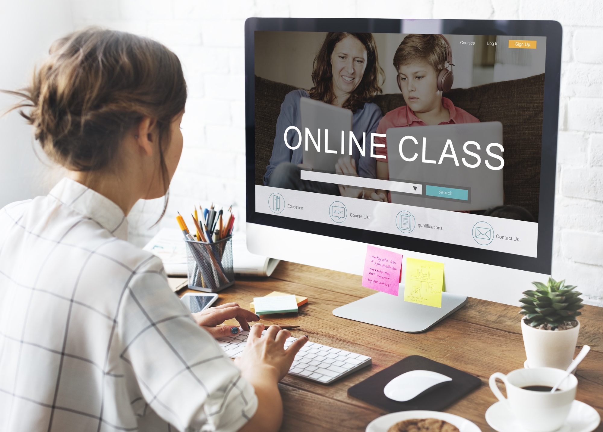 Brown-haired girl sitting at a desk with a computer screen displaying an online class