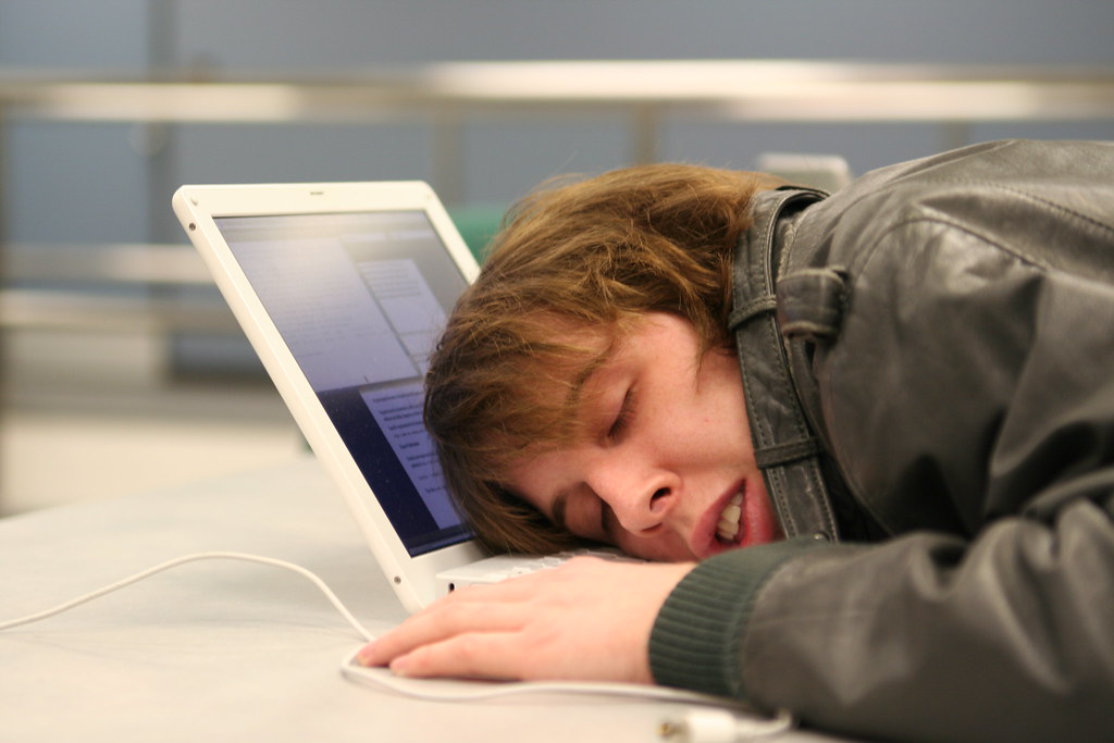 College student asleep on his computer