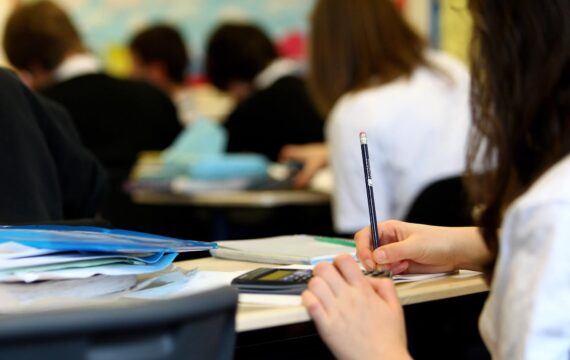 College student writing on a desk